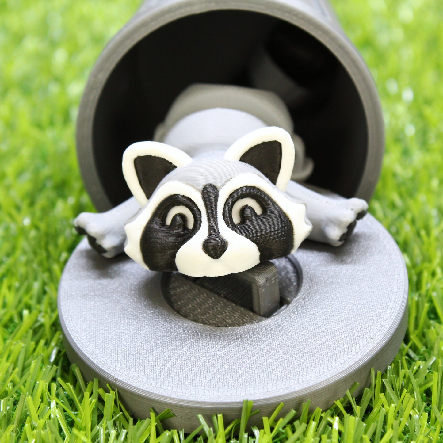 Raccoon inside of trashcan on grass.