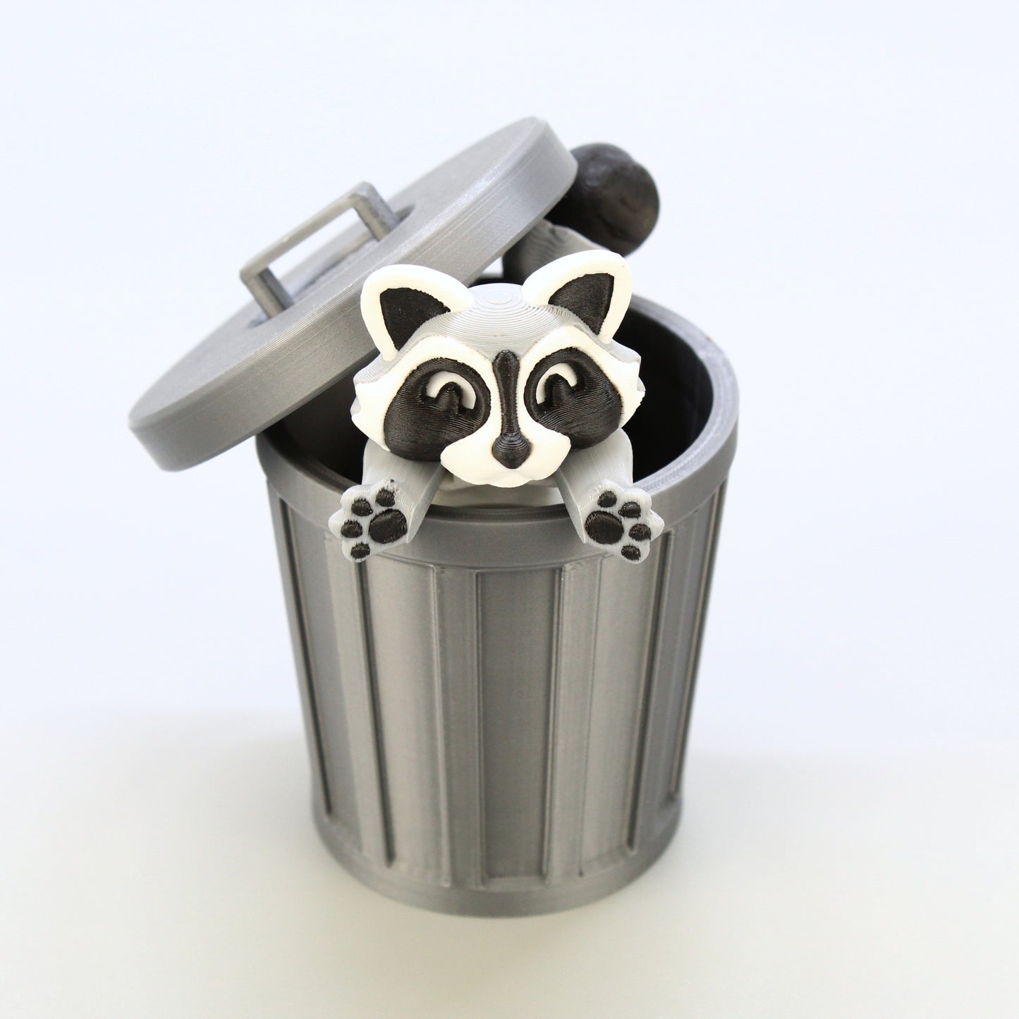 Raccoon inside of the trash can jumping out to surprise you.