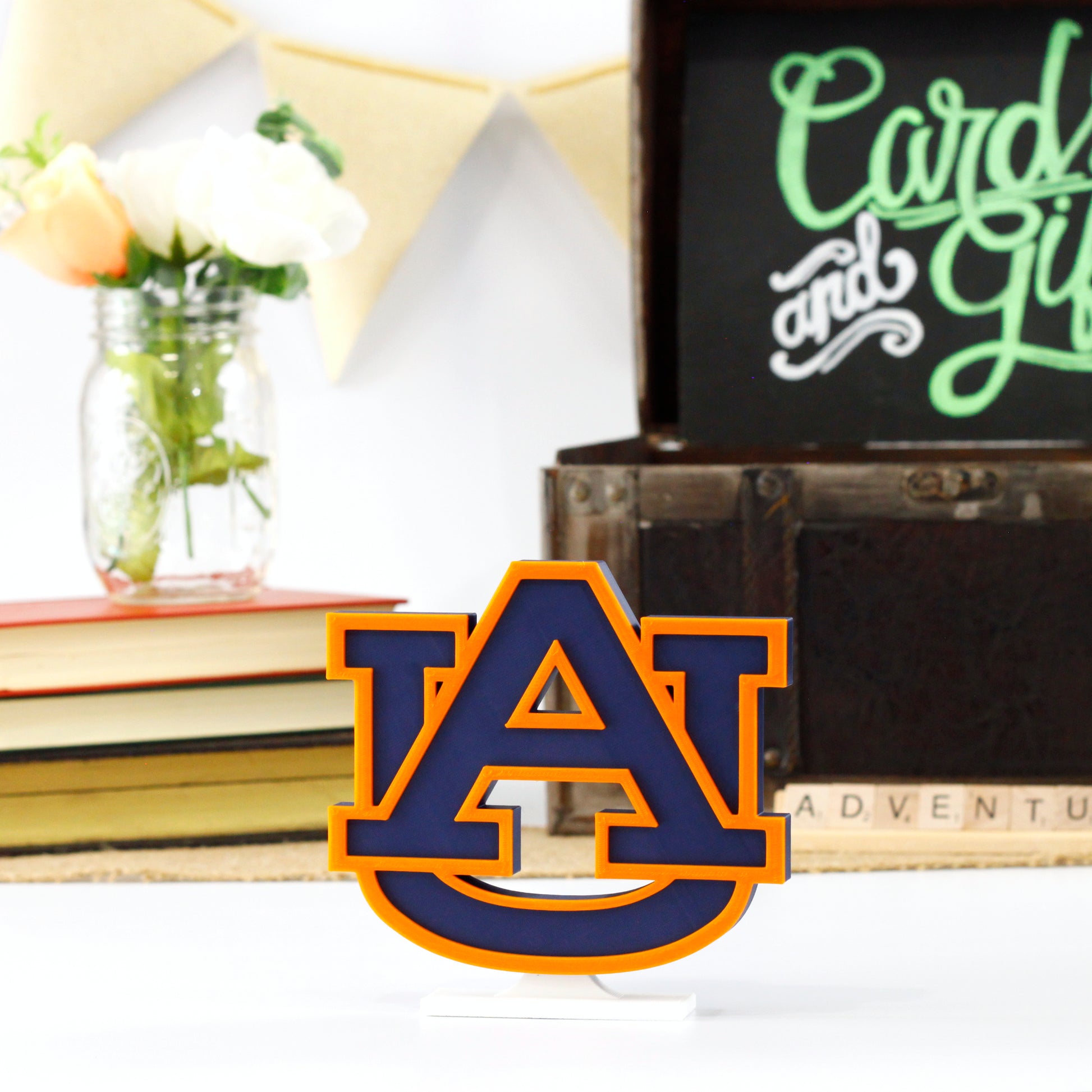 University of Auburn decoration in front of a stack of books and a chest for cards and gifts. Adventure in Scrabble titles.