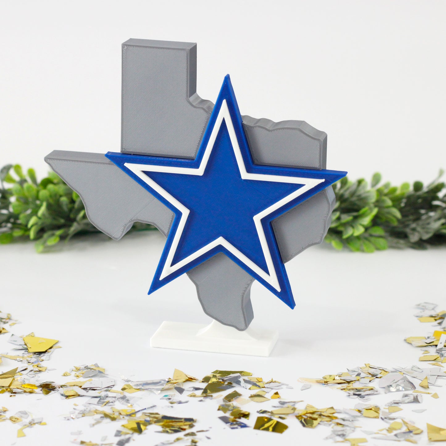 Dallas Cowboys decoration surrounded by confetti and ivy.