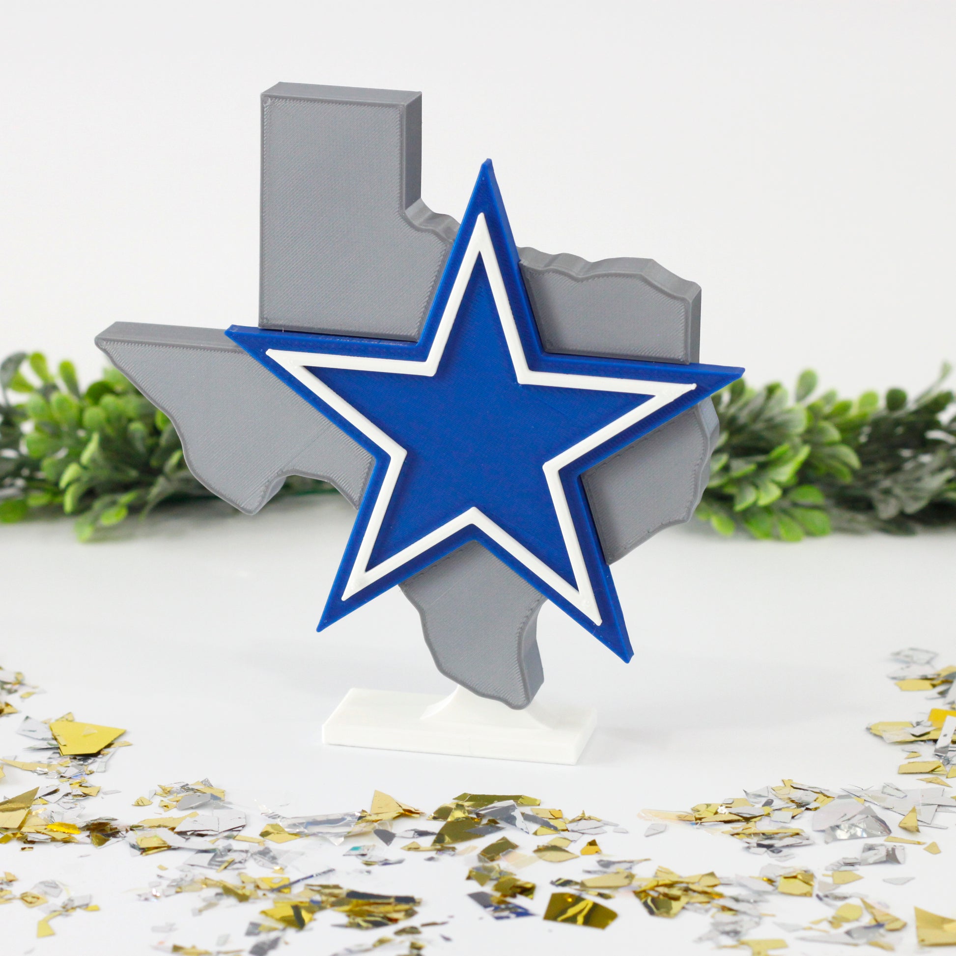 Dallas Cowboys decoration surrounded by confetti and ivy.