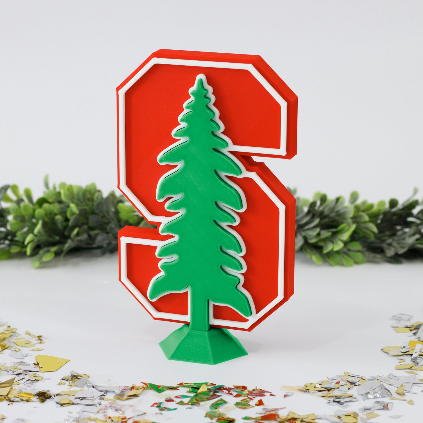 Stanford University Cardinals decoration surrounded with glitter with ivy behind it.