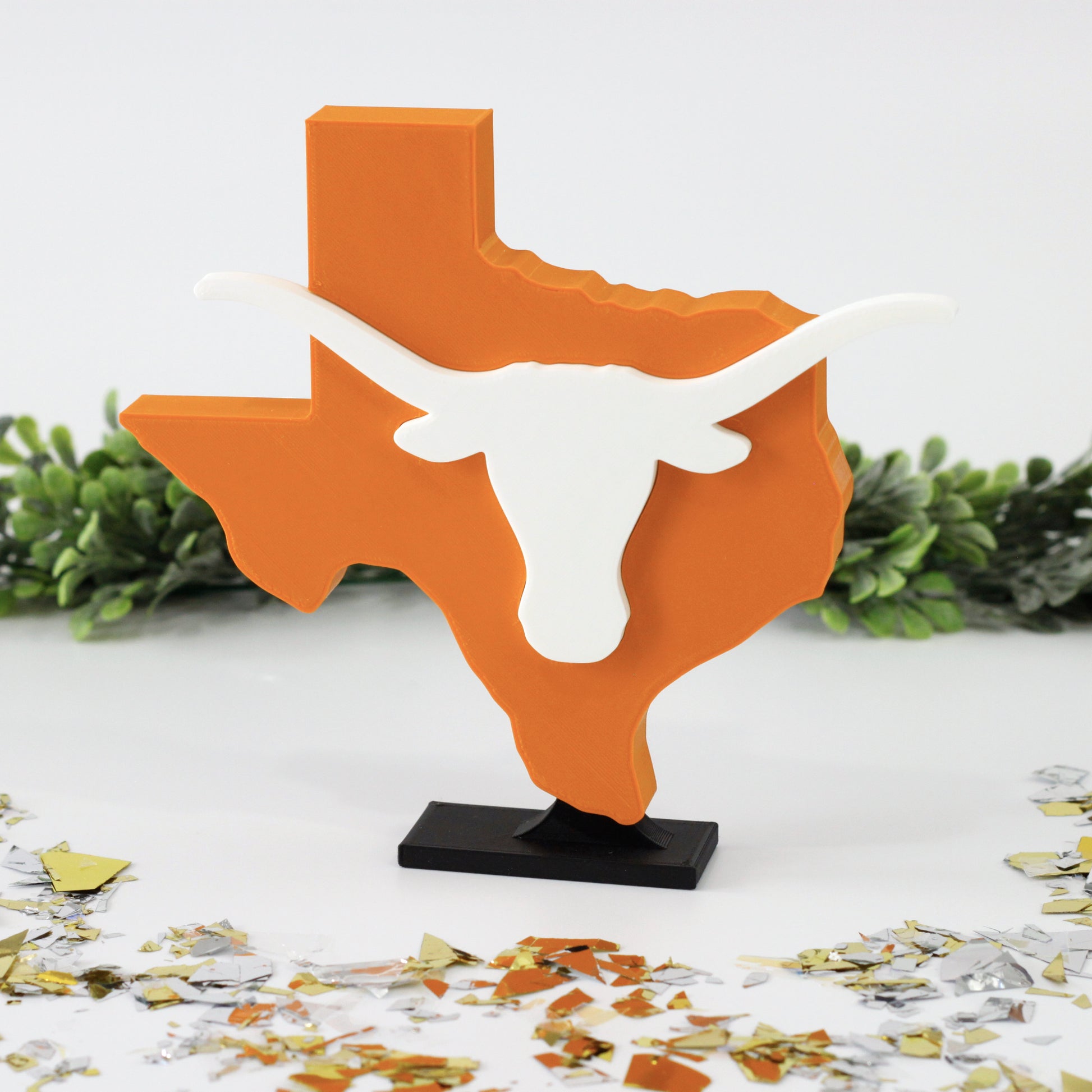 University of Texas Longhorn decoration surrounded by glitter with ivy behind it.
